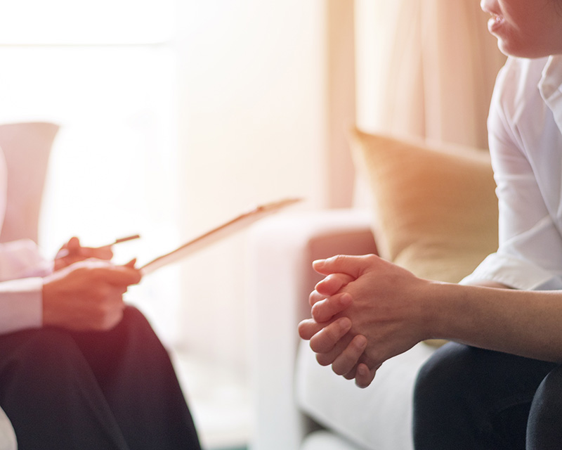 Therapist holding a clipboard doing a bio-psycho-social evaluation