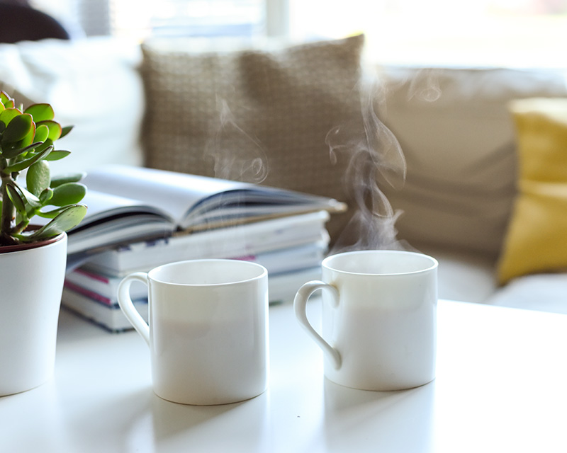 Two mugs on a coffee table.